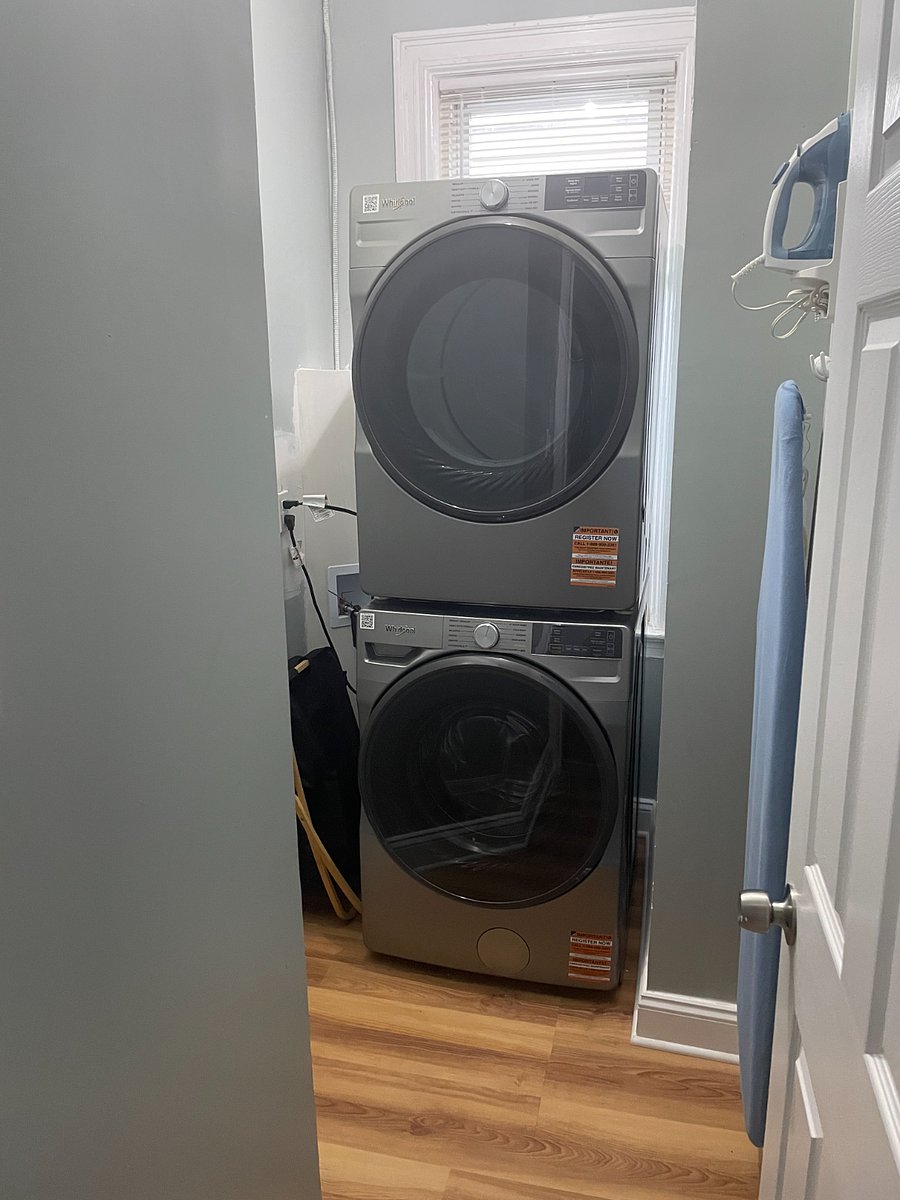 Stacked washer and dryer with iron and ironing board