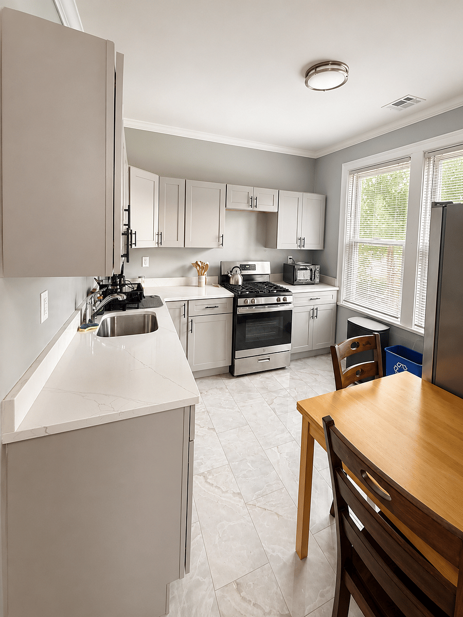 Bright kitchen with white cabinets, gas stove, and dining table